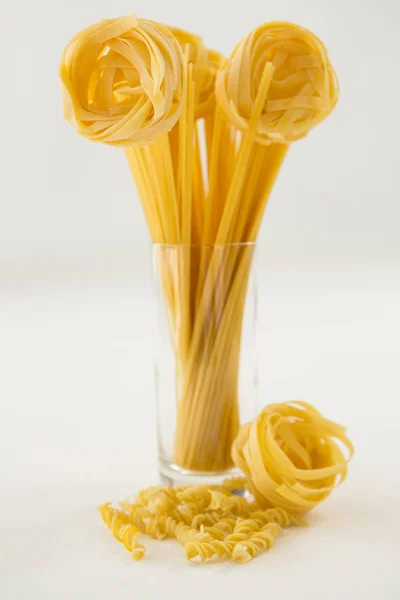 Variedades de macarrão formando flor em recipiente de vidro — Fotografia de Stock