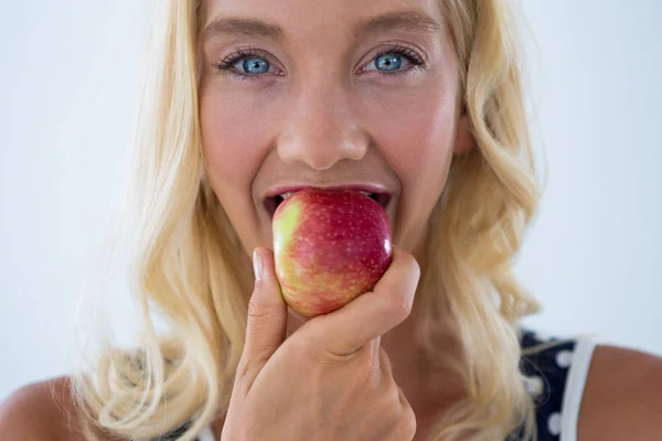 Retrato de una hermosa mujer comiendo manzana roja — Foto de Stock