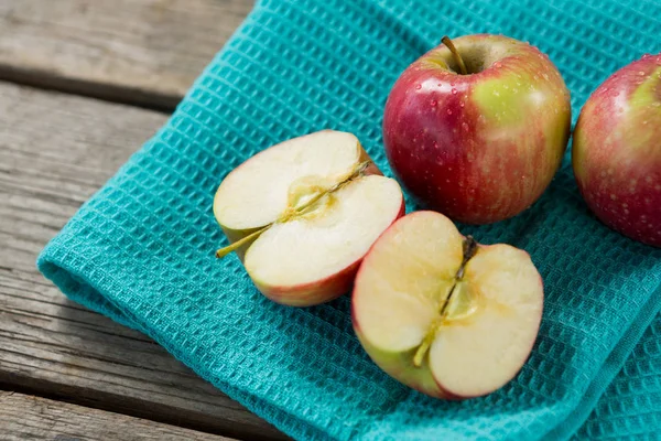 Close-up of red halved apples kept on cloth — Stock Photo, Image