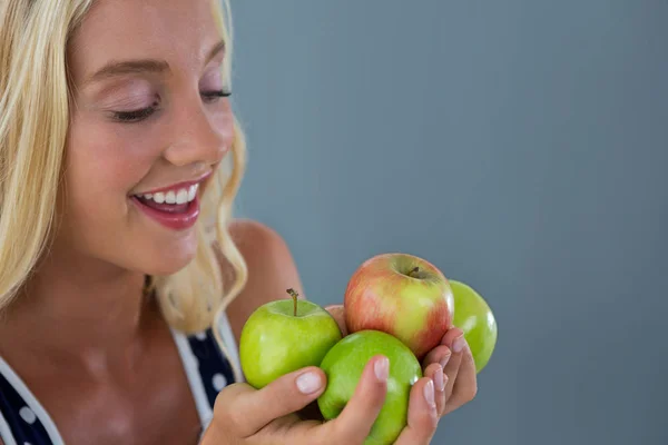 Mulher bonita segurando maçãs verdes — Fotografia de Stock