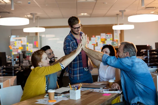 Creative business team giving a high five to each other — Stock Photo, Image