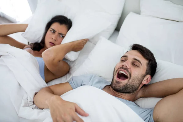 Woman getting disturbed with man snoring on bed — Stock Photo, Image