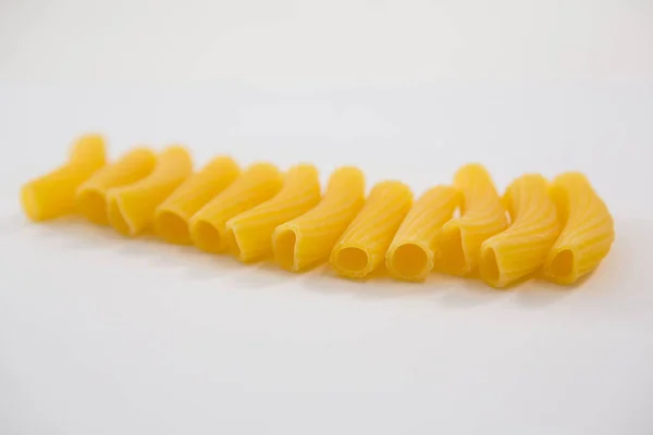 Sedani rigati pasta no fundo branco — Fotografia de Stock