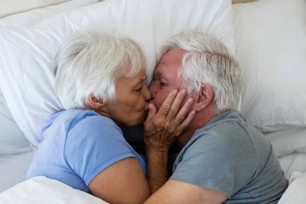 Seniorpaar küsst sich im Schlafzimmer — Stockfoto