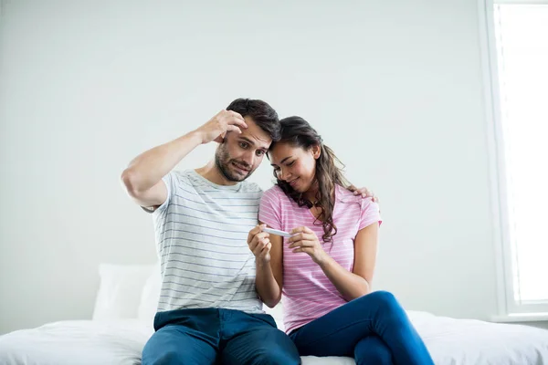 Paar erfährt Ergebnisse eines Schwangerschaftstests im Schlafzimmer — Stockfoto