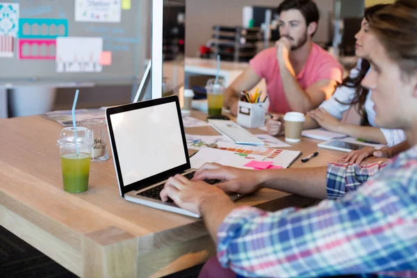 Man met laptop tijdens het werken met zijn team — Stockfoto