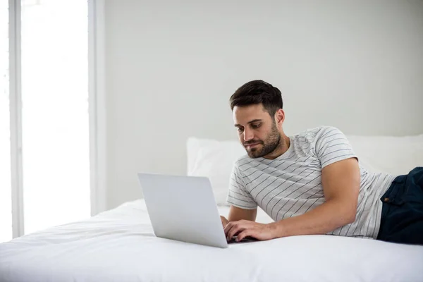 Hombre usando portátil en la cama —  Fotos de Stock