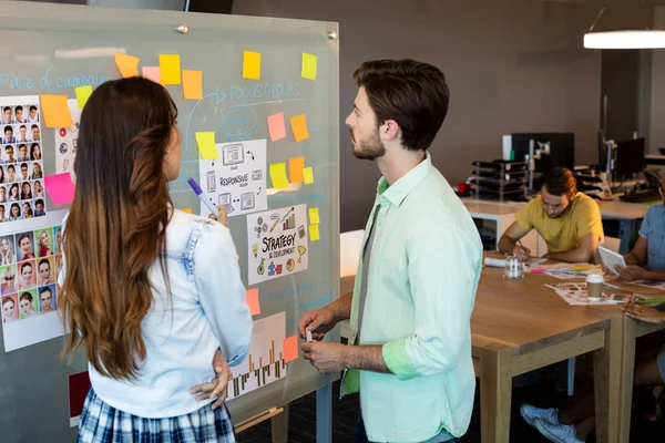 Orang-orang bisnis kreatif melihat catatan lengket di papan kaca — Stok Foto