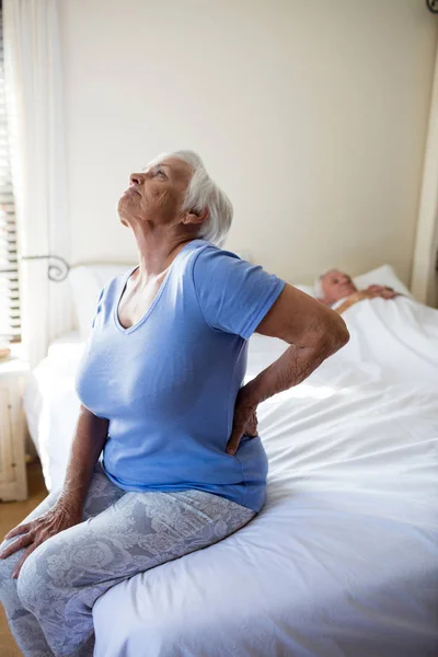 Senior vrouw lijden aan rugpijn in de slaapkamer — Stockfoto