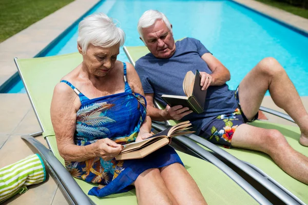 Senior couple reading books on lounge chair — Stock Photo, Image