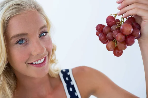 Beautiful woman holding at bunch of red grapes — Stock Photo, Image