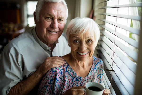 Retrato de pareja de ancianos de pie cerca de la ventana —  Fotos de Stock