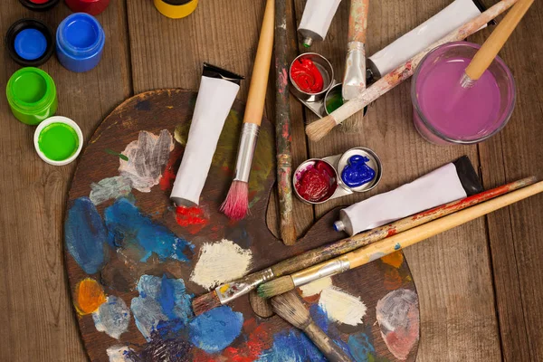 Palet met meerdere kleuren, aquarel en verf penselen — Stockfoto