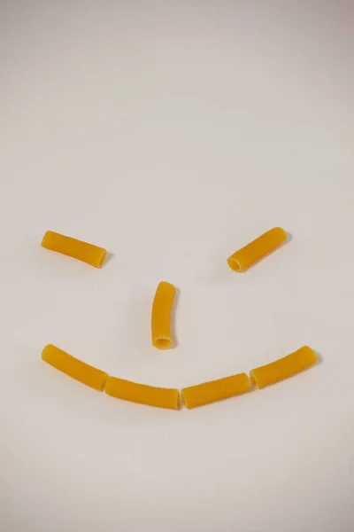 Smiley face made out of pennette pasta — Stock Photo, Image
