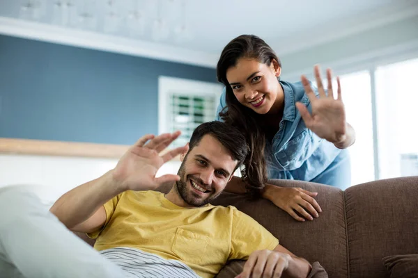 Retrato de pareja agitando las manos en la sala de estar —  Fotos de Stock