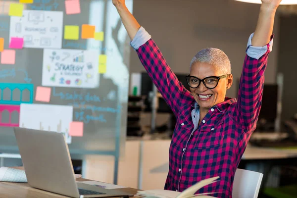 Creative businesswoman celebrating on desk — Stock Photo, Image