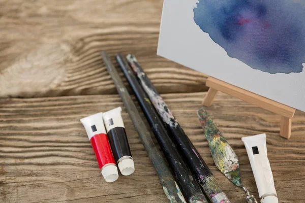 Акварельна фарба, пензлі та полотно на дерев'яній поверхні — стокове фото