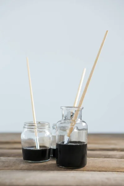 Paintbrushes with black paint dipped into water — Stock Photo, Image