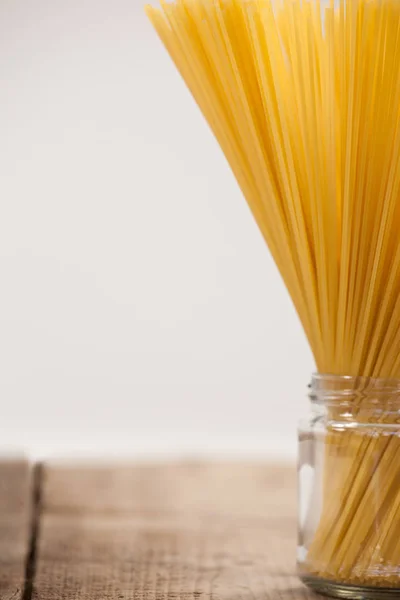 Paquete de espaguetis crudos en frasco de vidrio — Foto de Stock