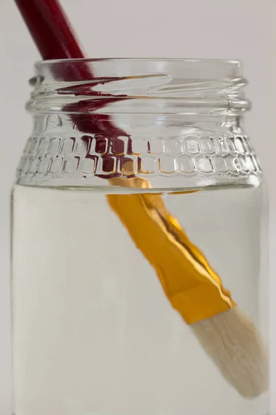 Pinsel in einem mit Wasser gefüllten Glas — Stockfoto