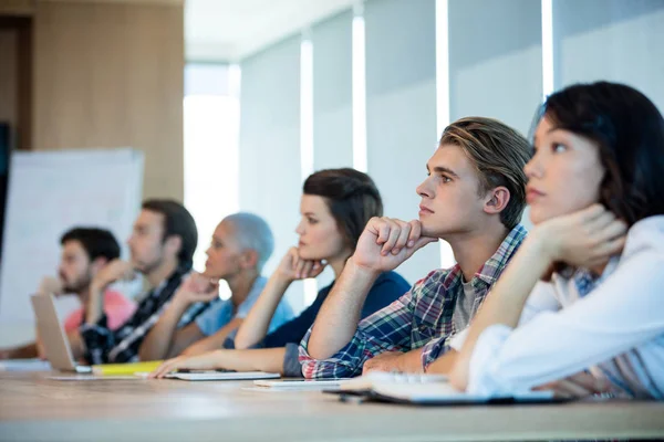 Team creativo di business in ascolto alla riunione in sala conferenze — Foto Stock