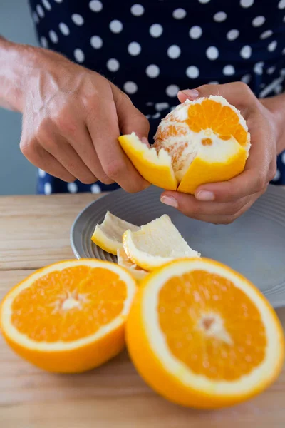 Mulher descascando laranja — Fotografia de Stock