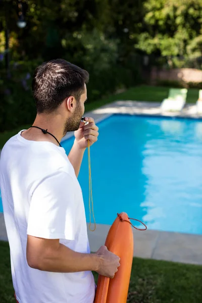 Lifeguard blowing whistle at poolside — Stock Photo, Image