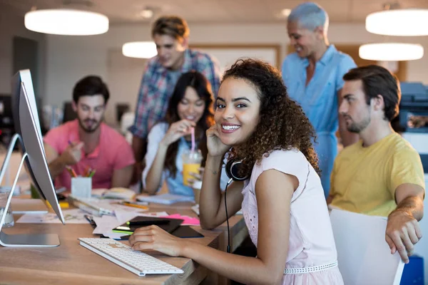 Femme souriante travaillant avec son équipe au bureau — Photo