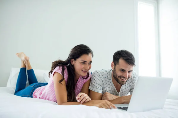 Pareja usando portátil en el dormitorio — Foto de Stock