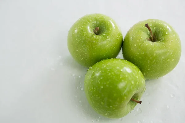 Su damlacıkları olan yeşil elmalara yakın çekim — Stok fotoğraf