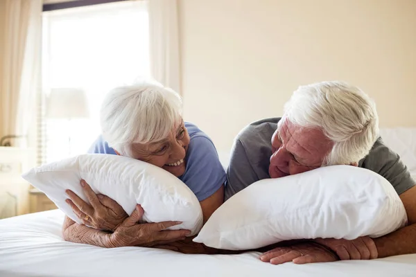 Happy senior couple lying on bed — Stock Photo, Image