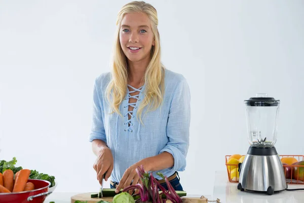 Портрет усміхненої жінки, що ріже овочі — стокове фото