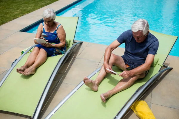 Senior paar met behulp van digitale tablet op lounge stoel — Stockfoto