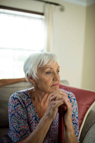 Smutné, starší žena sedící na gauči — Stock fotografie