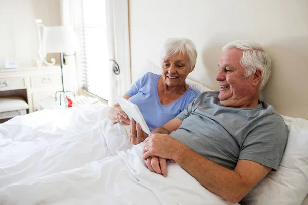 Senior paar met behulp van digitale tablet in de slaapkamer — Stockfoto