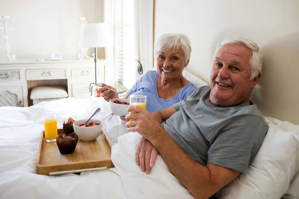 Ritratto di coppia anziana che fa colazione in camera da letto — Foto Stock