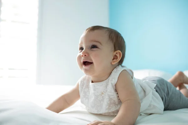 Bonito sorrindo bebê menina na cama — Fotografia de Stock
