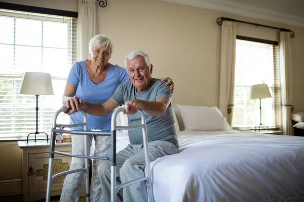 Senior kvinna att hjälpa mannen att gå med en walker — Stockfoto