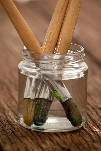 Paint brushes in a jar filled with water — Stock Photo, Image