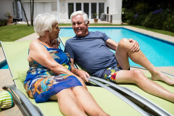 Senior couple interacting with each other on lounge chair — Stock Photo, Image