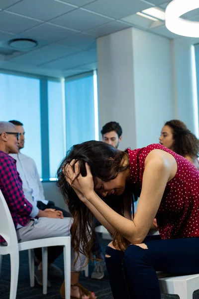 Mulher chorando enquanto equipe de negócios criativa no fundo — Fotografia de Stock