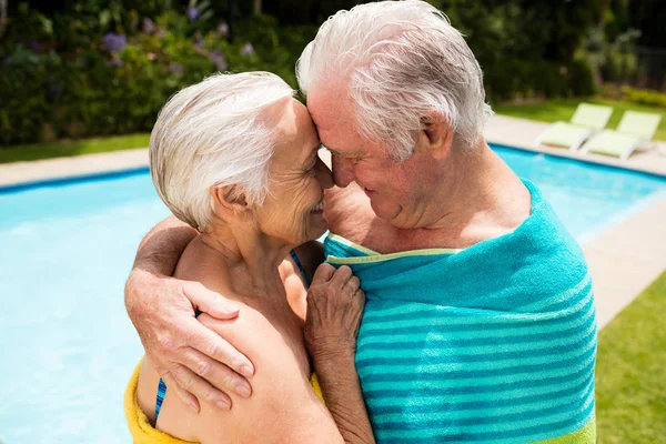 年长的夫妇互相拥抱在池畔 — 图库照片