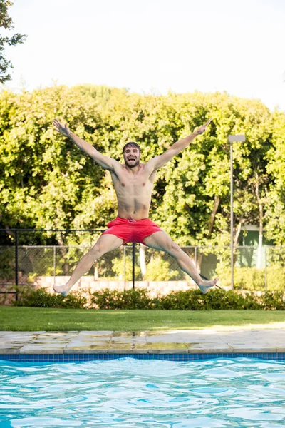 Jonge man springen in het zwembad — Stockfoto