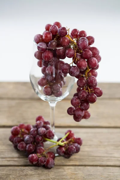 Bando de uvas vermelhas em copo de vinho — Fotografia de Stock