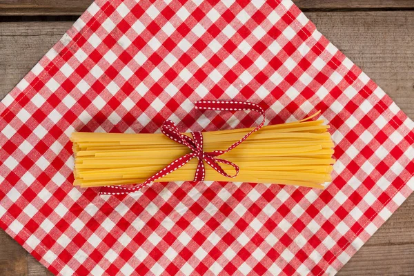 Pacote de espaguete cru amarrado com fita vermelha — Fotografia de Stock
