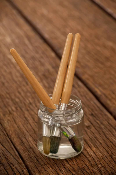 Paint brushes in a jar filled with water — Stock Photo, Image