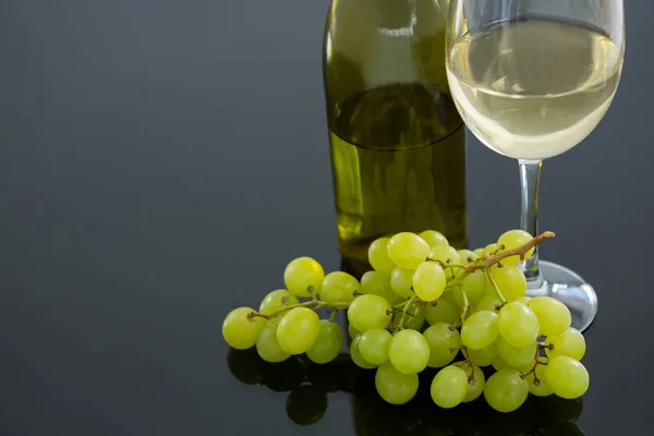 Közeli kép: zöld csomó szőlő üveg és üveg bort — Stock Fotó