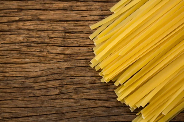 Spaghetti pasta on wooden surface — Stock Photo, Image