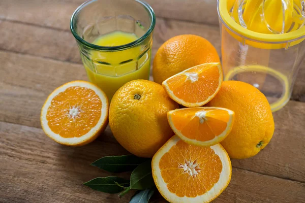 Close-up van sinaasappelen met glazen SAP en juicer — Stockfoto