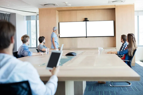 Man met een tablet terwijl het bijwonen van een vergadering in de vergaderzaal — Stockfoto